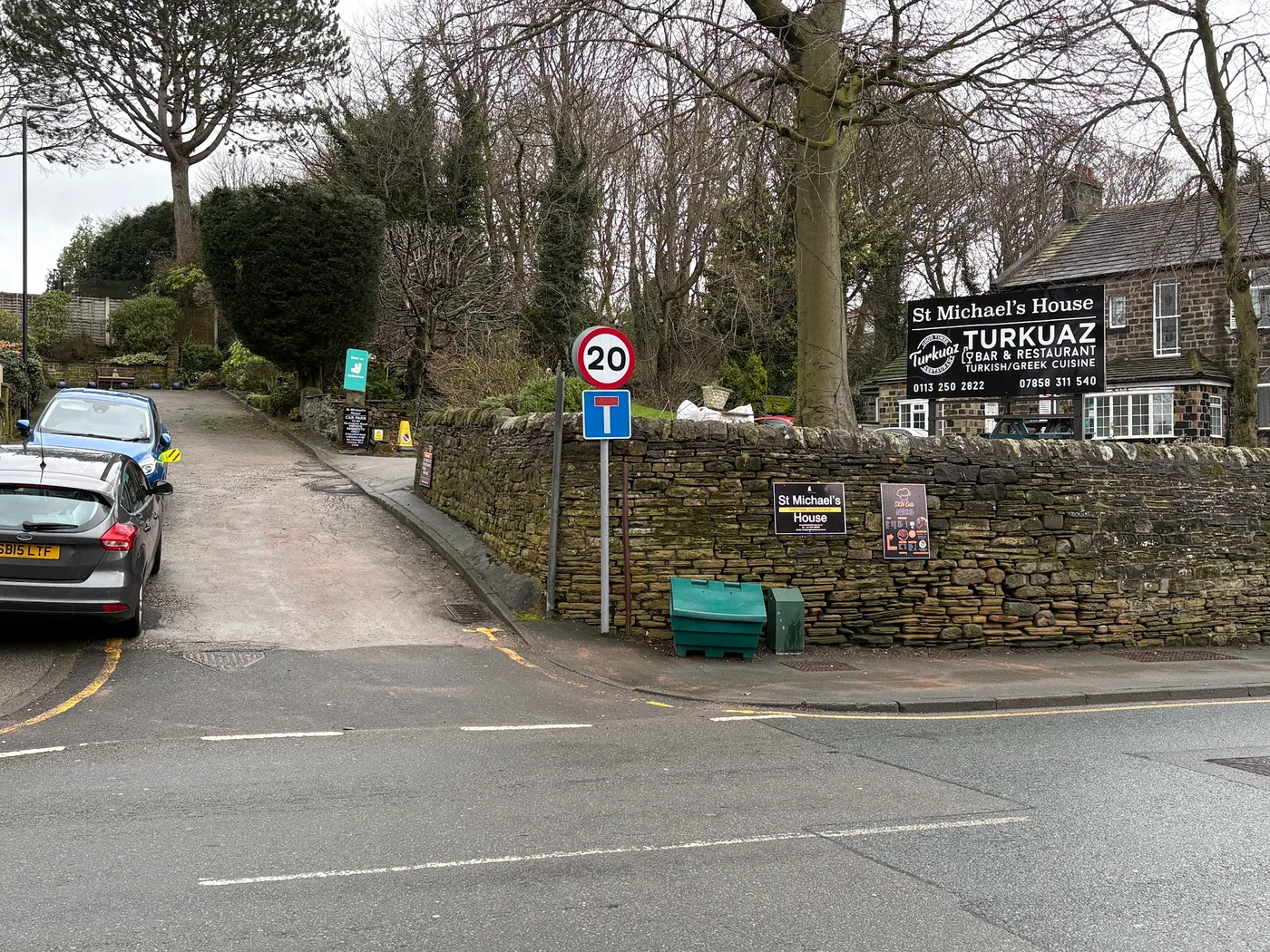 The driveway entrance from Harrogate Road, beside the orange SKN Eats sign
