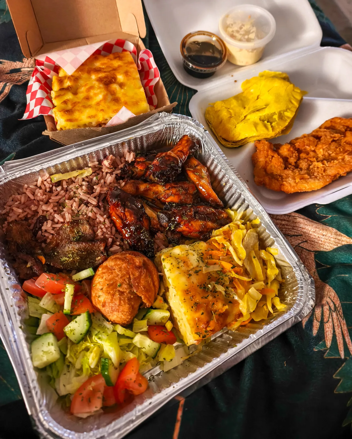 A generous SKN Eats takeaway spread with rice, chicken, sides and salad